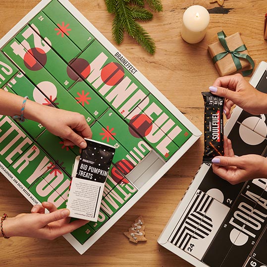 Zwei Adventskalender auf Holzunterlage