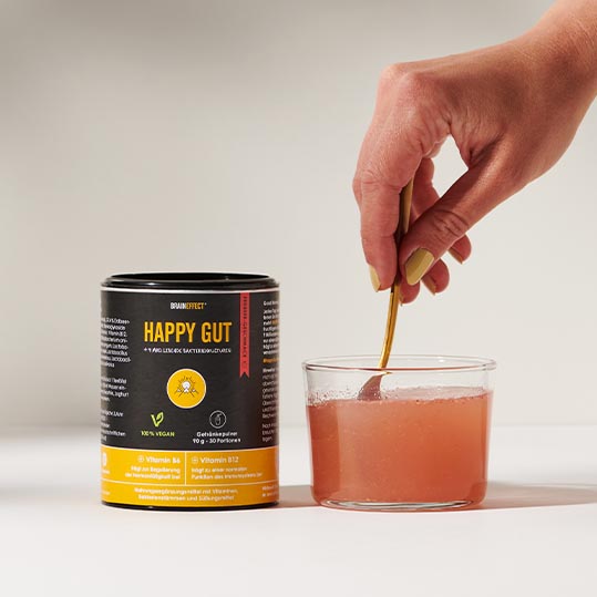 Hand rührt Happy Gut im Glas um