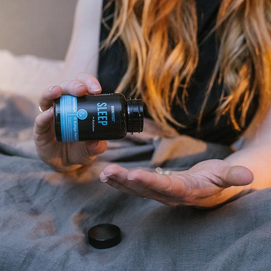 Frau benutzt Sleep Kapseln mit Melatonin für verkürzte Einschlafzeit