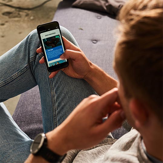 Mann mit Handy Coaching App